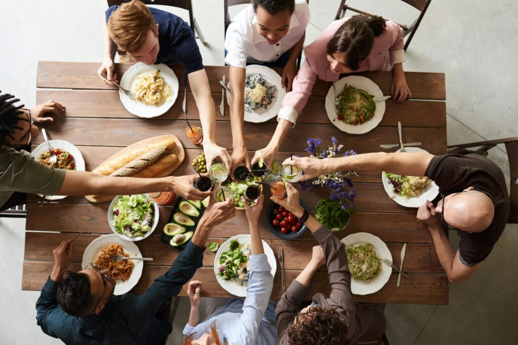 Overhead view of a group toasting at a shared table during a celebration meal